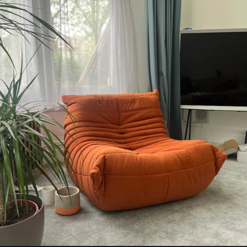 Orange modern lounge chair in a living room.