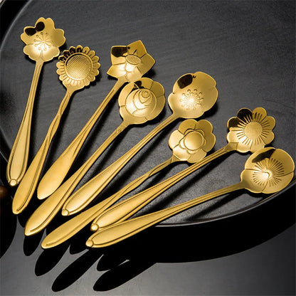 Several golden spoons with flower-shaped heads on a black tray.