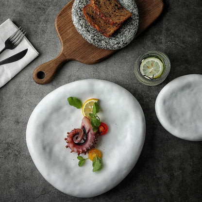 Plated dish with octopus and vegetables on a textured surface