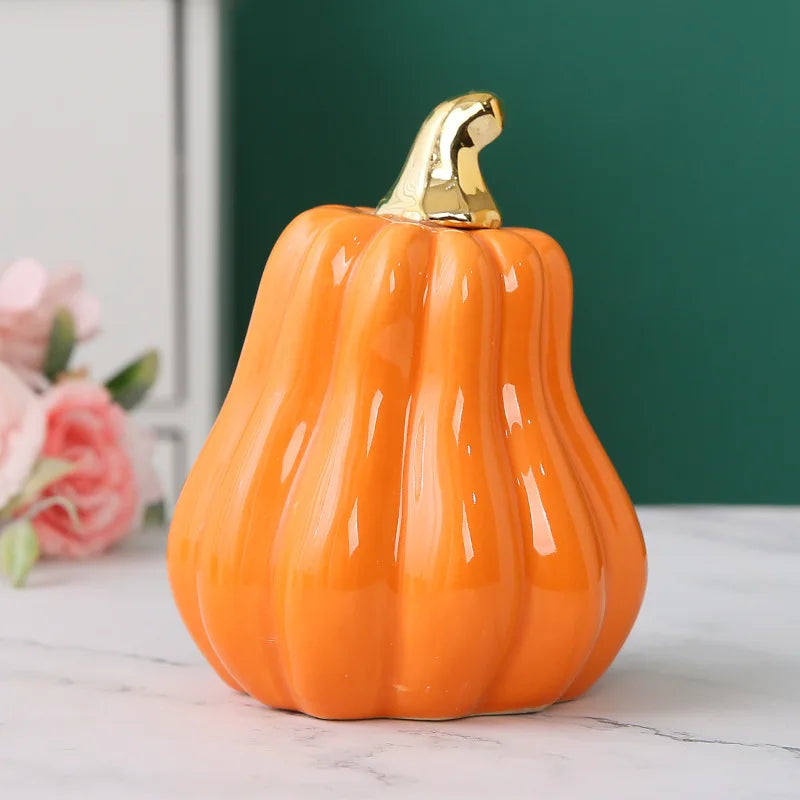 A single tall, glossy orange ceramic pumpkin with a golden stem sits on a marble surface.