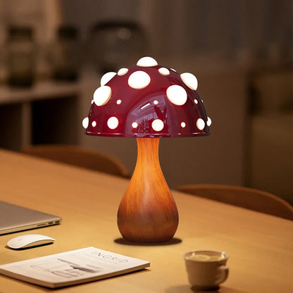 A mushroom-shaped lamp with a red cap and white spots, on a wooden table.