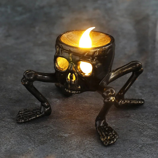 A lit candle inside a skull-shaped holder with skeletal legs.