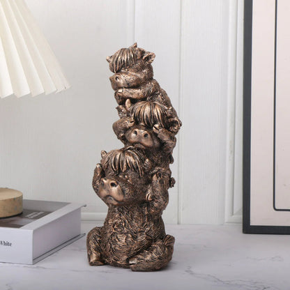 Bronze sculpture of four stacked animals on a white surface with a neutral background