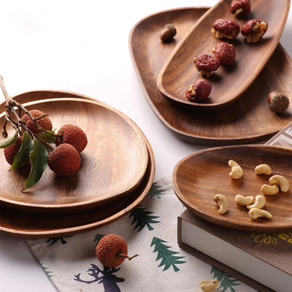 A set of assorted wooden serving trays holding lychees, dried fruits, and cashews.