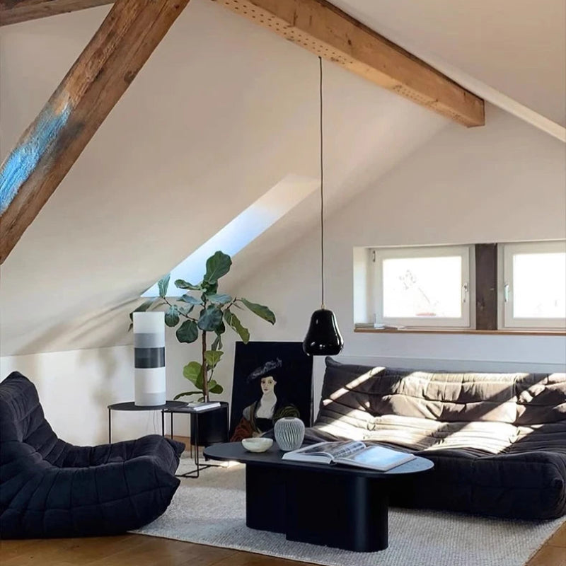 Loft living room with black sofa and exposed beams.