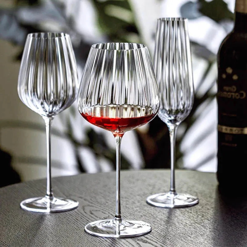 Three fluted glasses and a wine bottle.