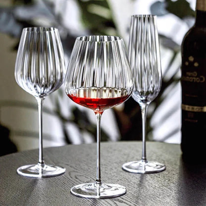 Three fluted glasses and a wine bottle.
