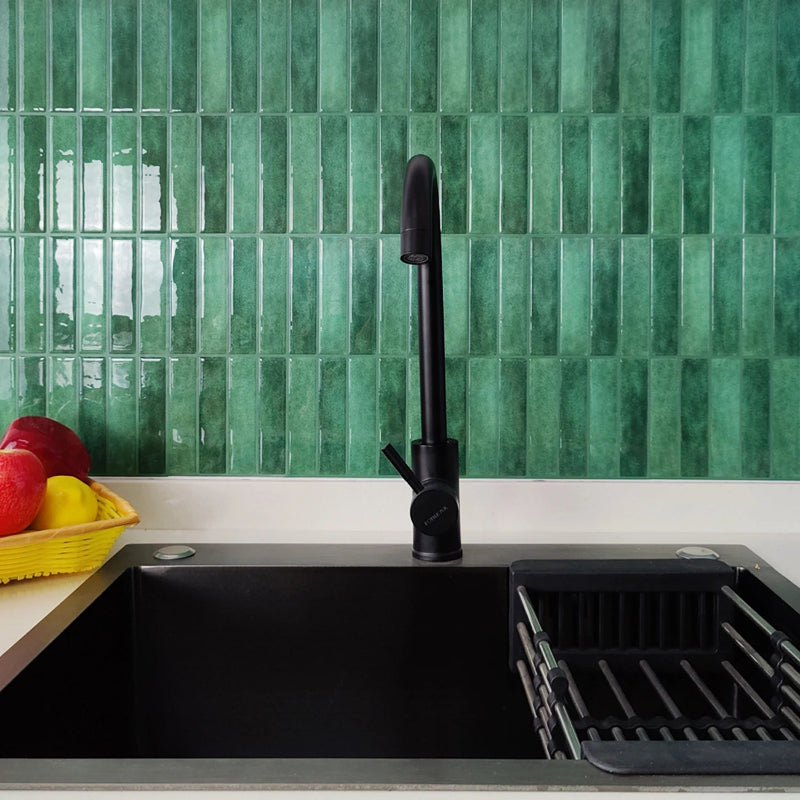 Kitchen sink with black faucet and green tile backsplash