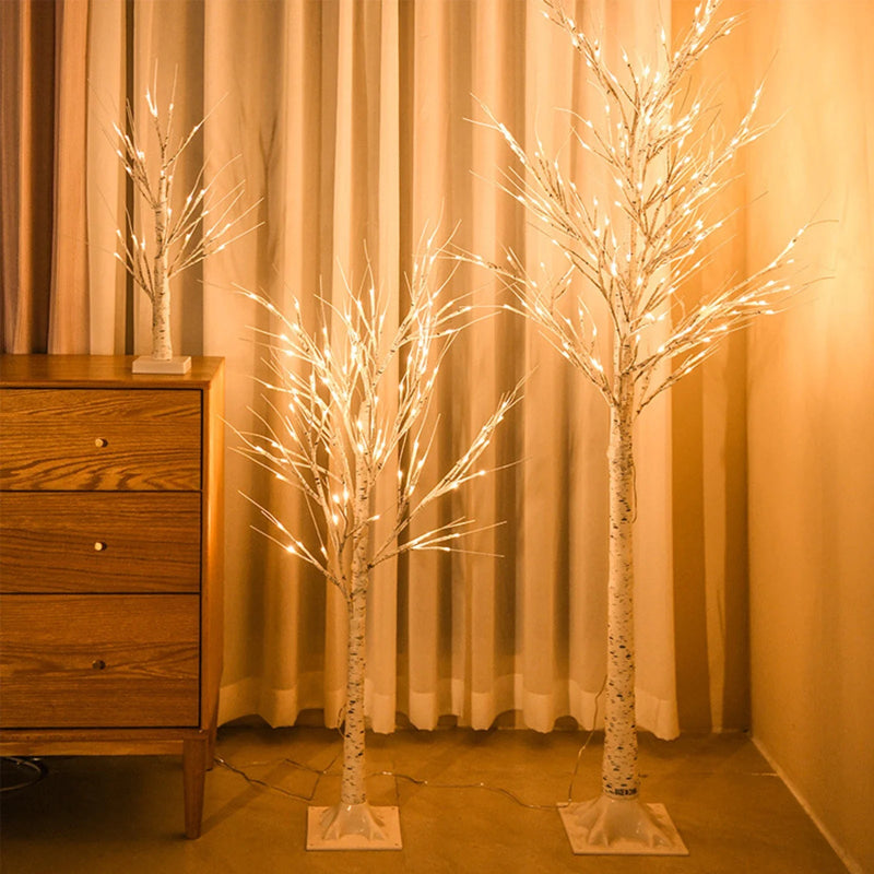 Decorative LED trees with lights on a wooden dresser against a curtain backdrop