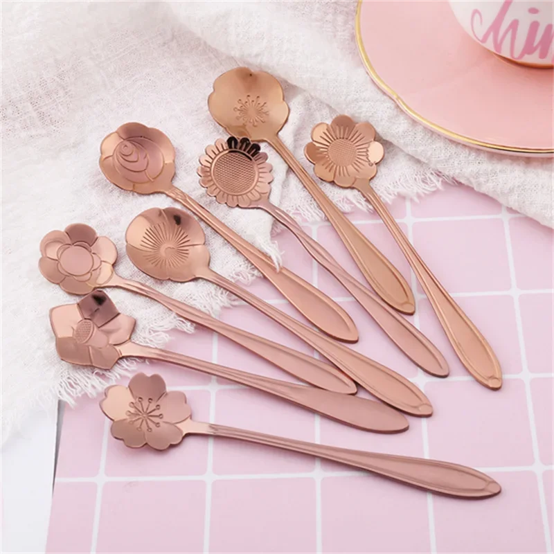 Rose gold flower spoons on a pink and white checkered surface.