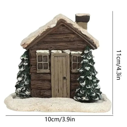 Miniature cabin with snow-covered roof and trees on a white background