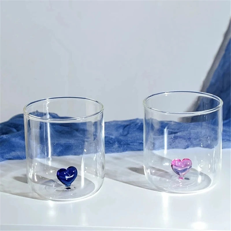 Two clear glasses with heart-shaped bottoms.