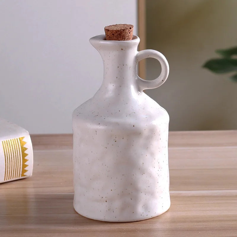 White ceramic bottle with cork stopper on a wooden surface