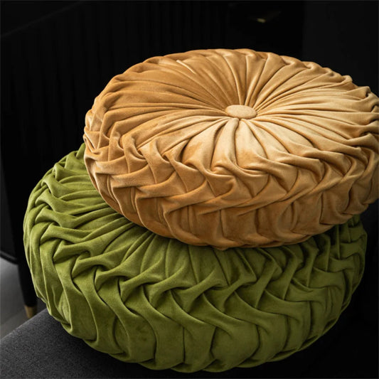 Two round, textured cushions in beige and green on a dark background