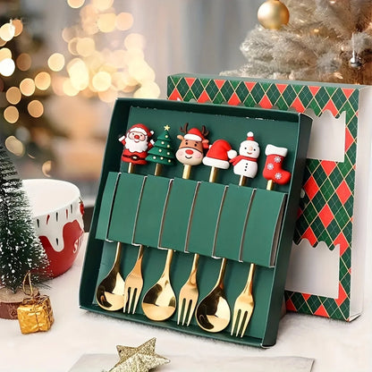 Set of gold Christmas-themed spoons in a decorative box with a festive background.