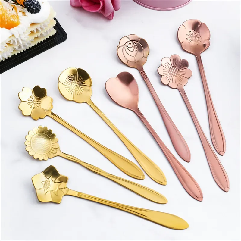Golden and rose gold flower spoons on a white surface.