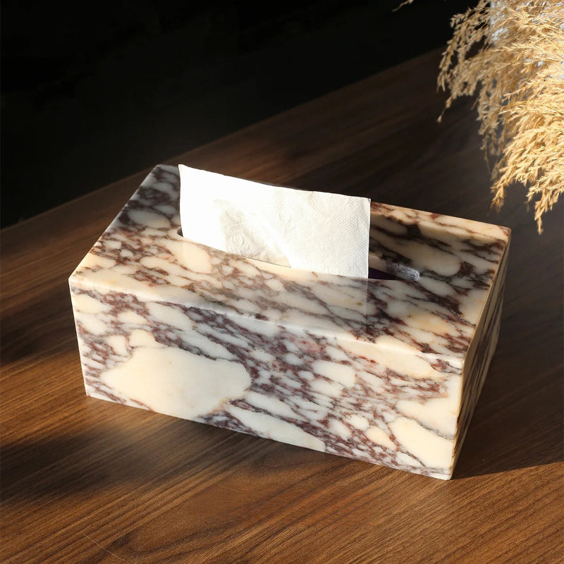 Marble-patterned tissue box on a wooden surface with a dark background