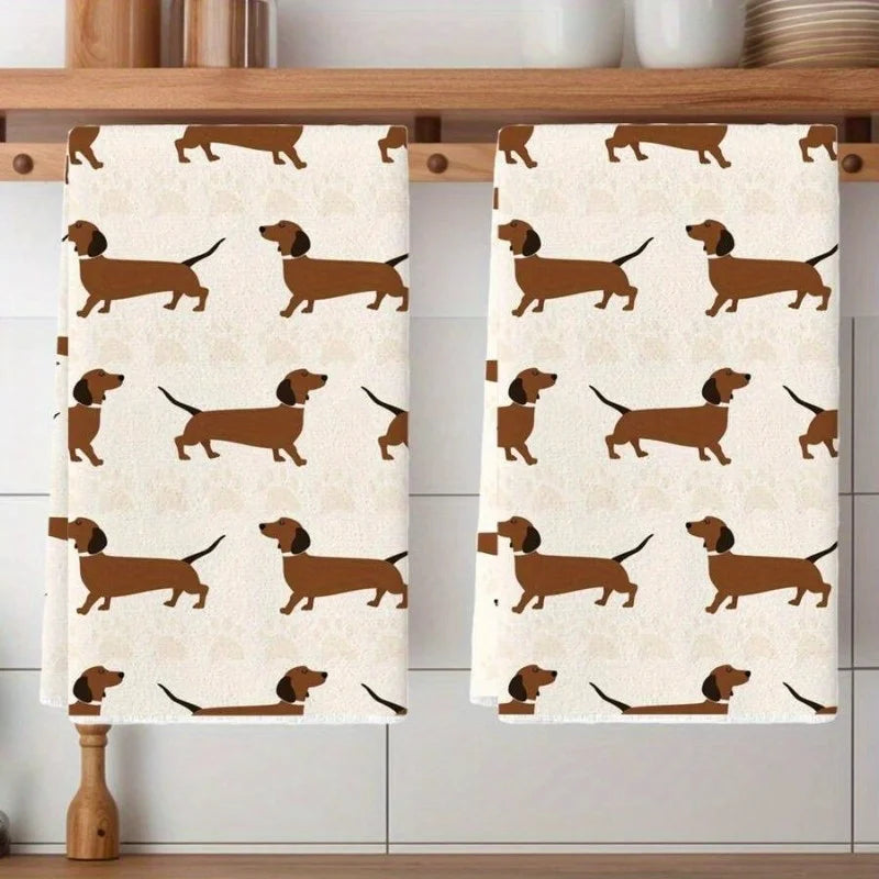 Two kitchen towels with dachshund pattern on a wooden cabinet.