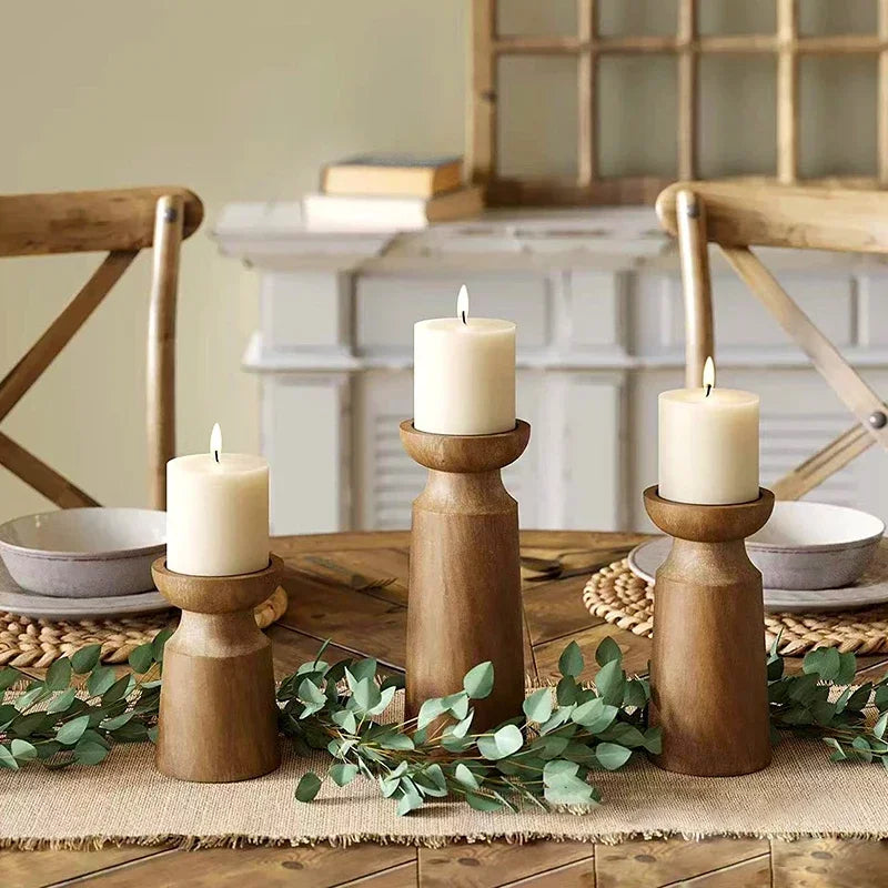 Wood candle holder set styled on a dining table with lit candles, adding a cozy ambiance to a dinner setting.