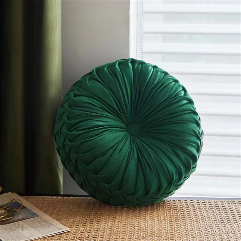 Green round pillow on a textured surface with a window in the background