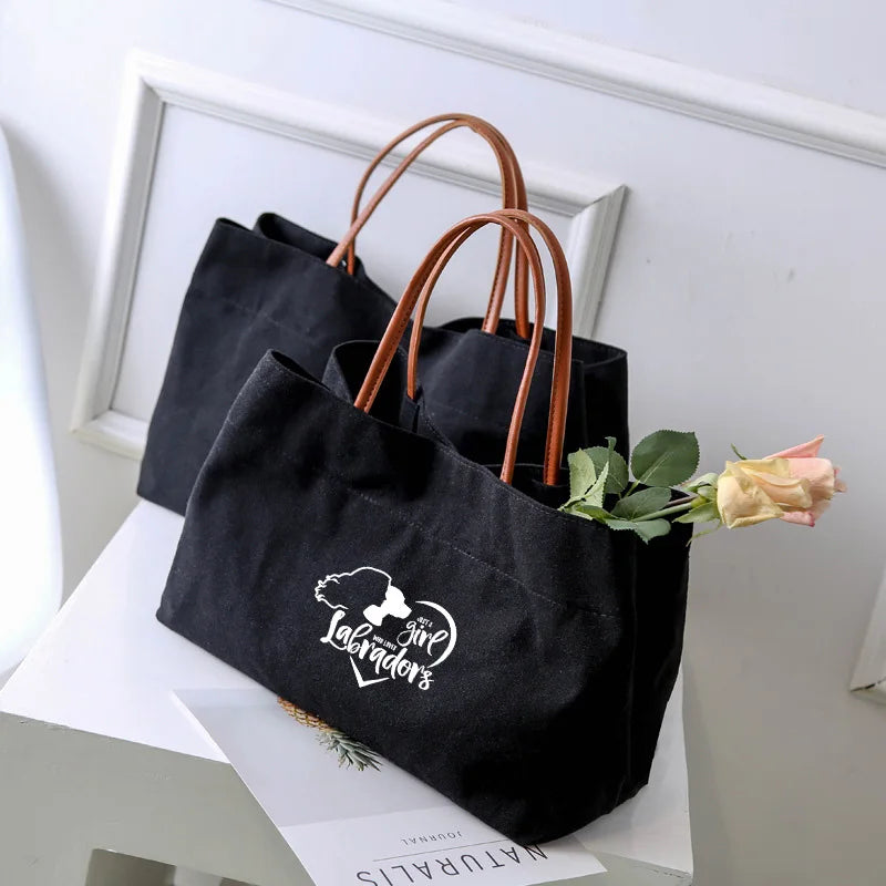 Two black canvas tote bags, one with a "Give Me Labradors" graphic.