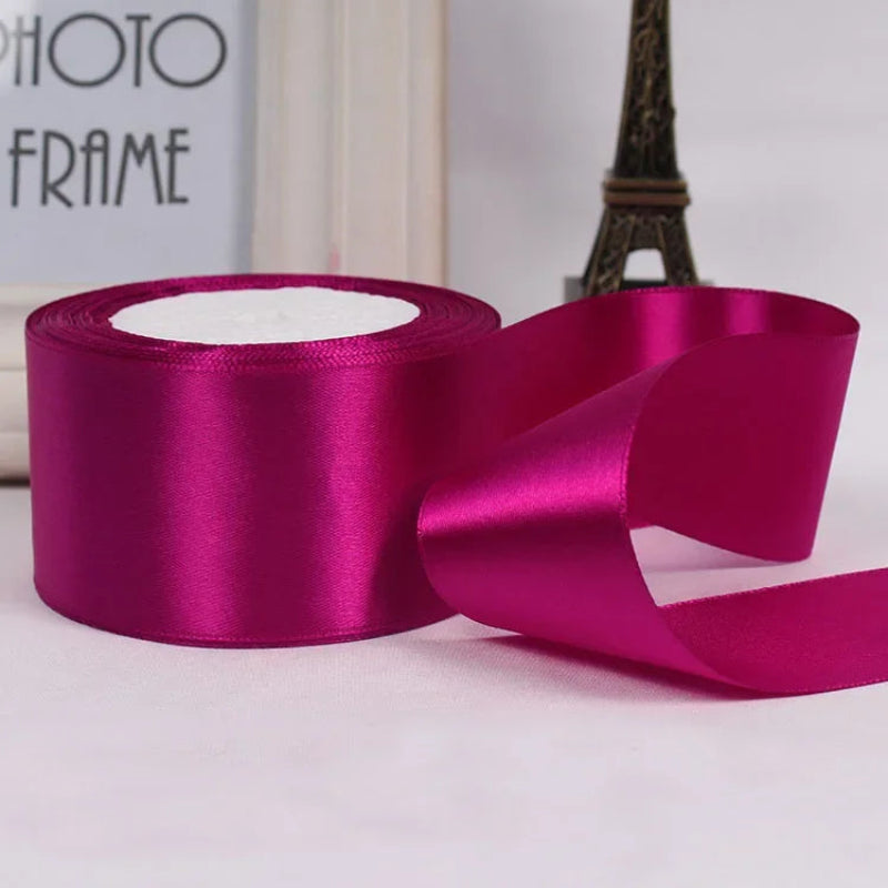 Roll of pink satin ribbon with a blurred background