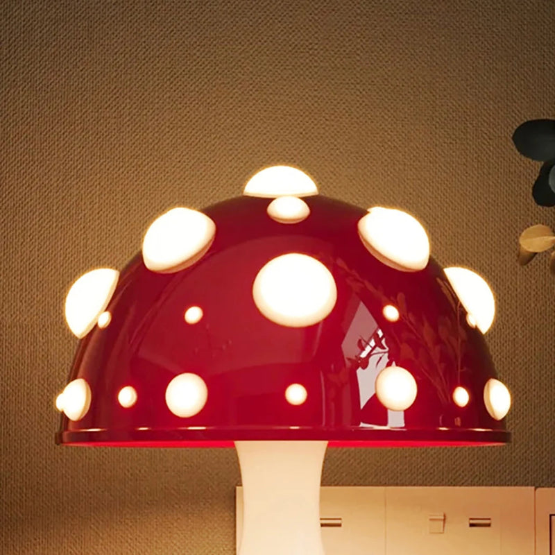 A close-up of a mushroom-shaped lamp with a red cap and glowing white spots.