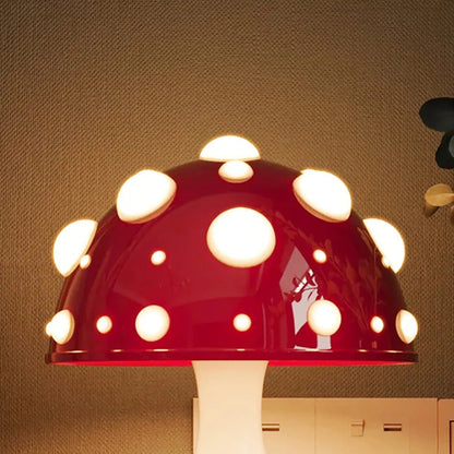 A close-up of a mushroom-shaped lamp with a red cap and glowing white spots.