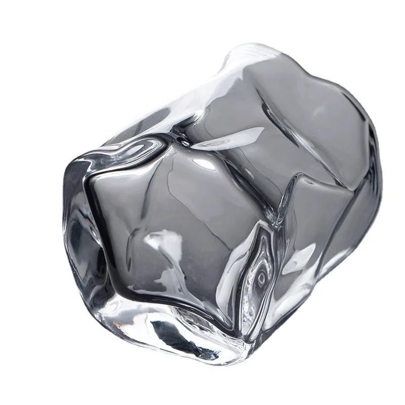 A unique, clear glass with a crumpled or textured design, shown on a white background.