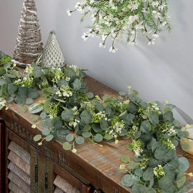 Artificial eucalyptus garland gracefully draped over a shelf, bringing a fresh, natural touch to the room with its lifelike greenery.