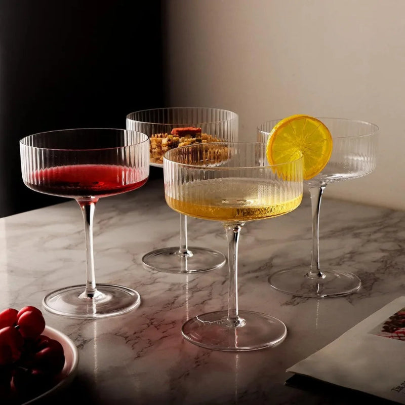 Set of cocktail glasses with drinks and garnishes on a marble surface