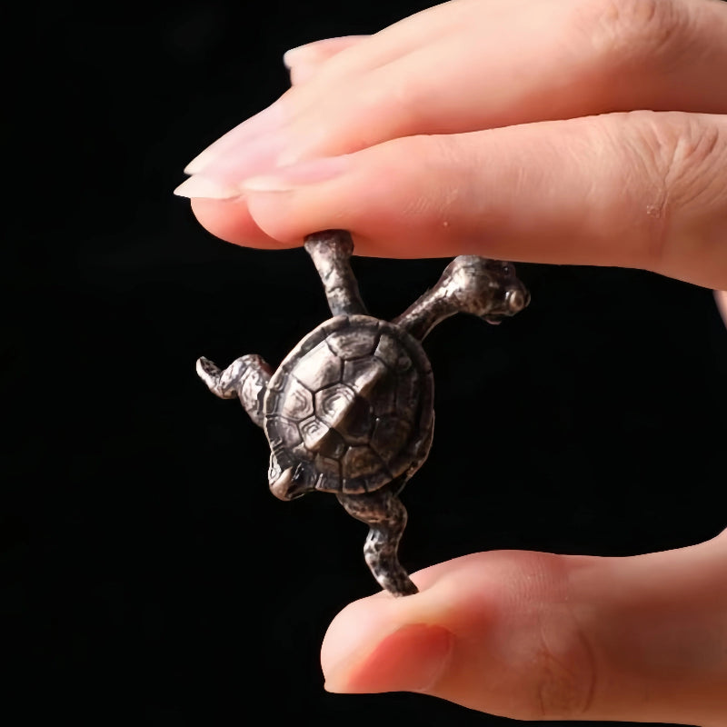 A hand holding a small, turtle figurine.