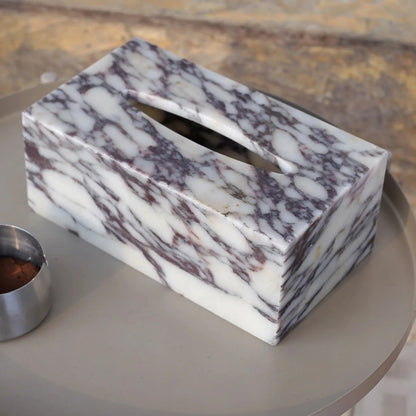 Marble-patterned tissue box on a round table with a blurred background