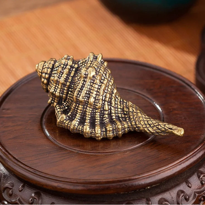 Bronze shell sculpture on a wooden stand with 'bobonuonuo' branding.