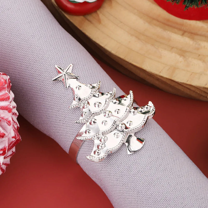 Silver Christmas tree napkin ring on a gray napkin with a red background