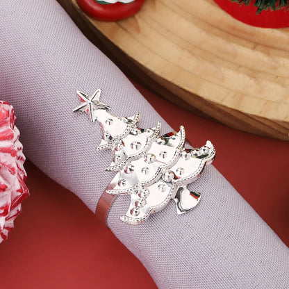 Silver Christmas tree napkin ring on a gray napkin with a red background