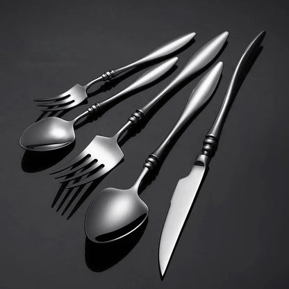 A set of six dark silver utensils on a black background.