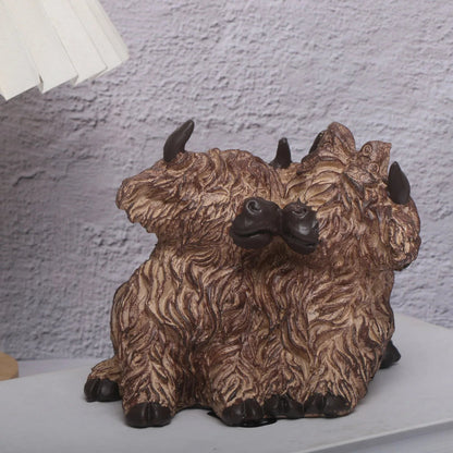 Decorative sculpture of a multi-headed creature on a white surface with a textured wall background