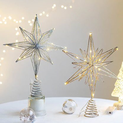Two light-up, glitter wire star Christmas tree toppers, one silver, one gold.