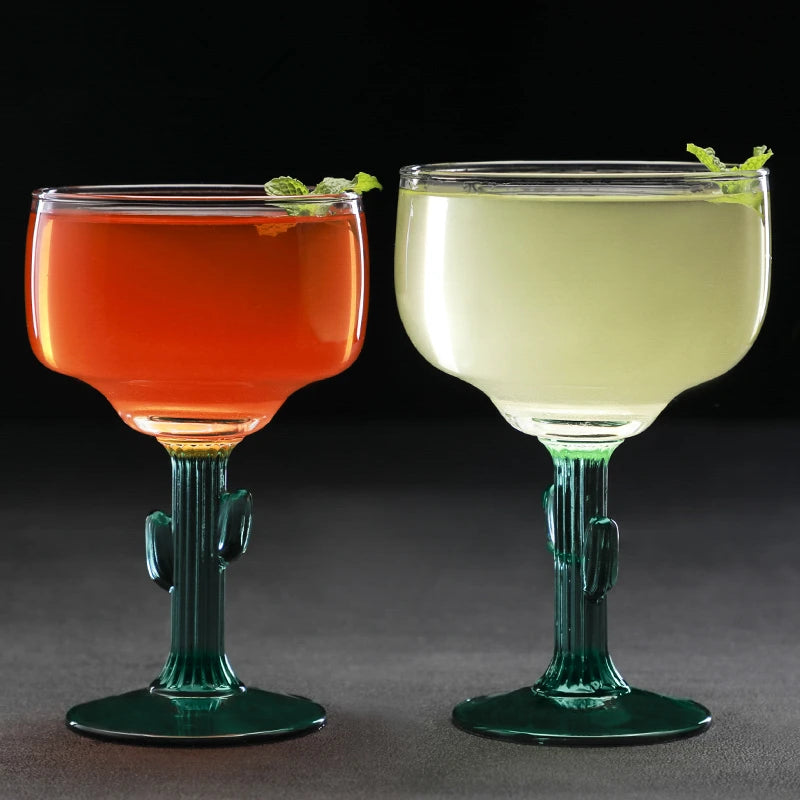 Two colorful cocktails in cactus-shaped glasses on a dark background