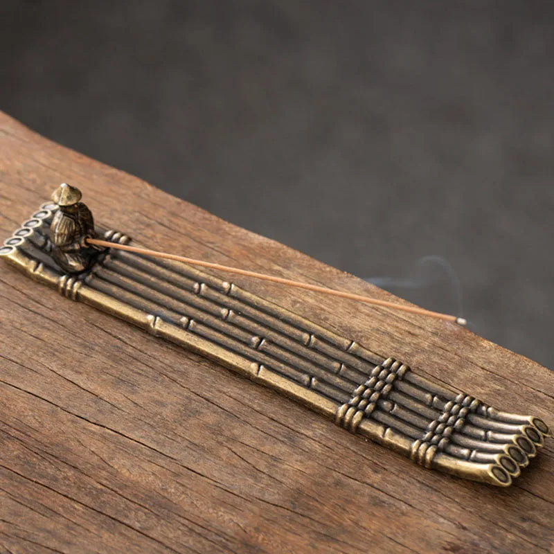 Bronze incense burner with smoke on a wooden surface