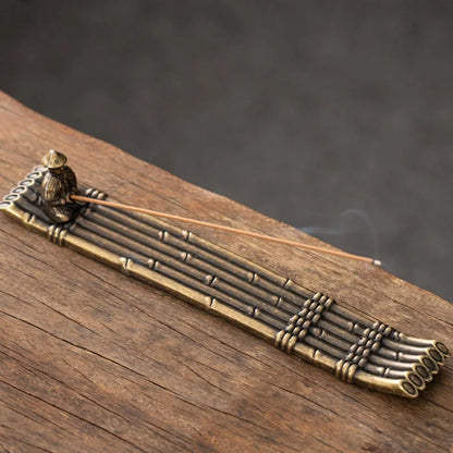 Bronze incense burner with smoke on a wooden surface