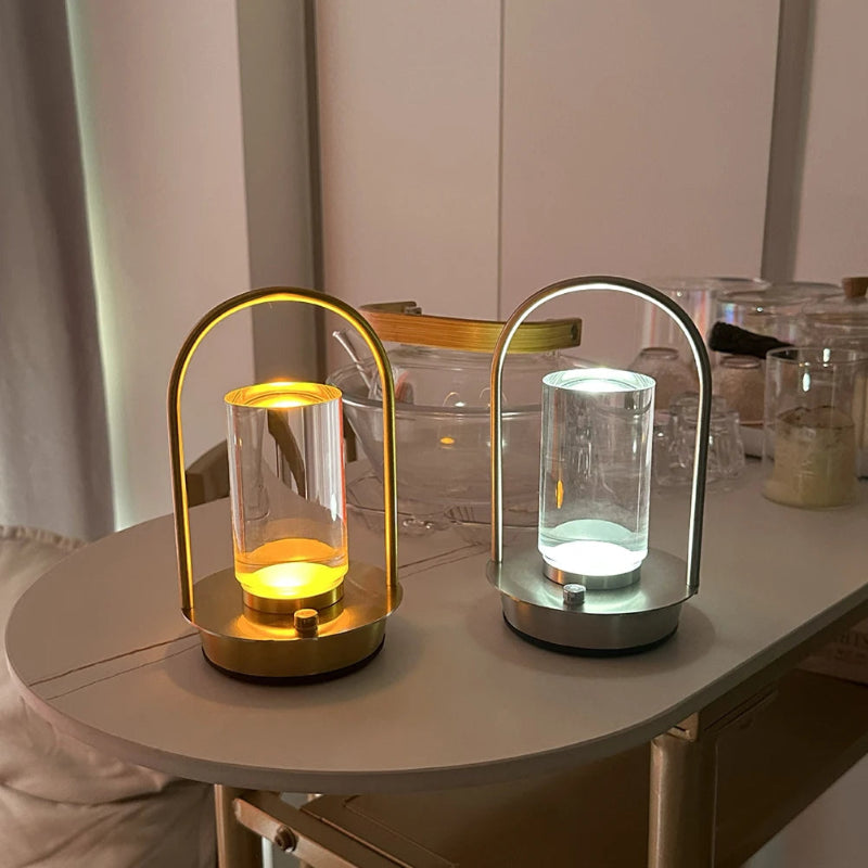 Two modern portable table lamps, one with a warm yellow light and the other with a cool white light, sitting on a light-colored table.