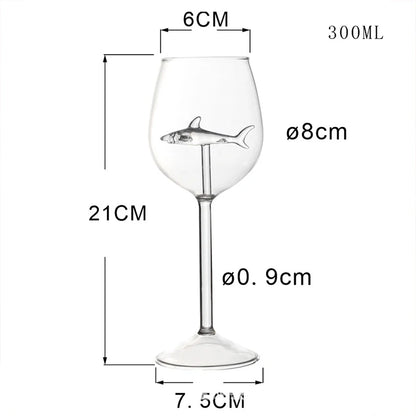A product image of an empty wine glass with a shark figurine inside, labeled with its dimensions.