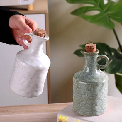Two ceramic bottles with cork stoppers on a surface with a blurred background