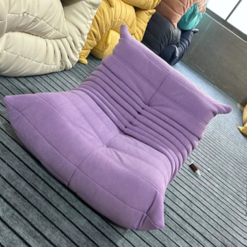 Purple modern lounge chair on a striped rug.