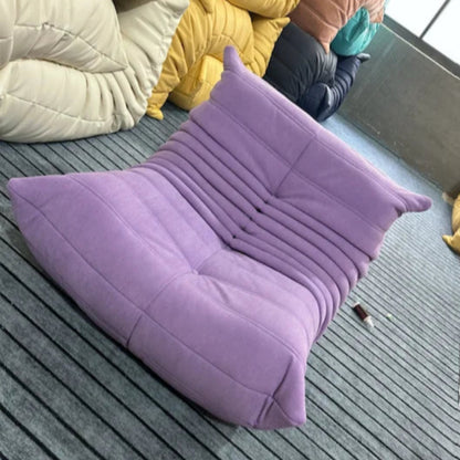 Purple modern lounge chair on a striped rug.