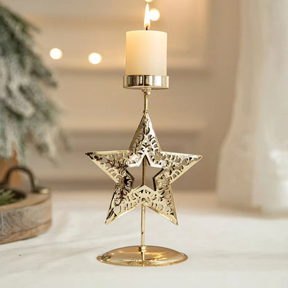 Lit candle in a gold star-shaped candle holder on a white surface.
