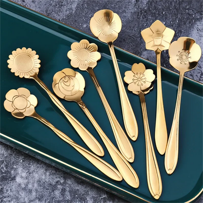 Several golden spoons with flower-shaped heads on a green tray.
