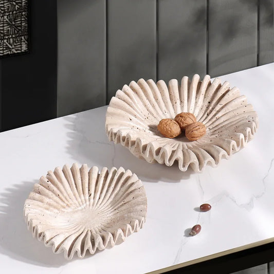 Neutral-toned travertine bowl with organic scalloped design.